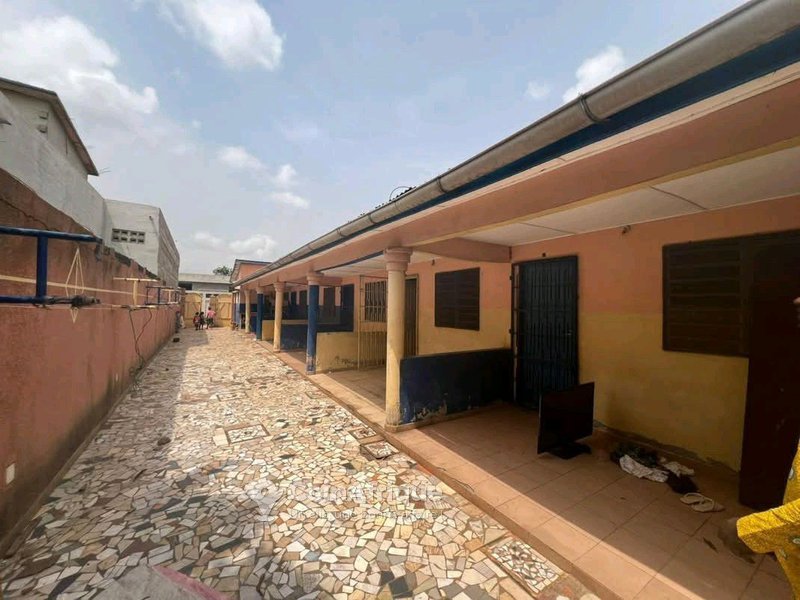 Maison locative sanitaire de 7 pièces avec véranda, boutiques et titre foncier global