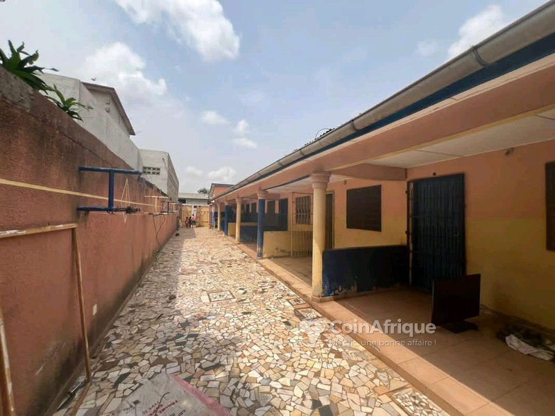 Maison locative sanitaire de 7 pièces avec véranda, boutiques et titre foncier global