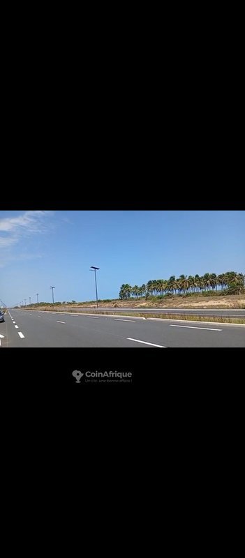 Terrain viabilisé de 500 m² avec titre foncier global en bordure de route goudronnée