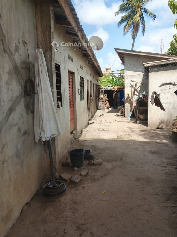 Propriété locative inachevée avec 5 modules chambre-salon et boutiques dallées