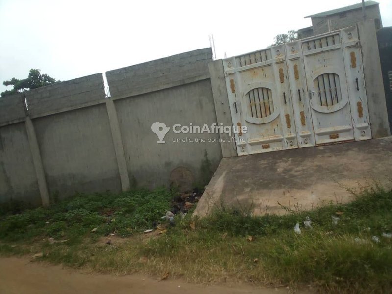 Terrain clôturé avec bâtiment inachevé et titre foncier personnel