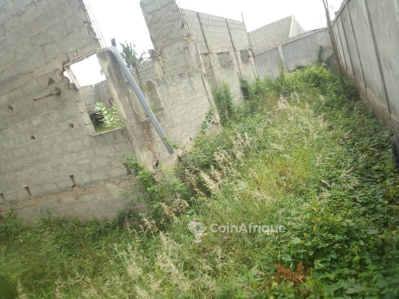 Terrain clôturé avec bâtiment inachevé et titre foncier personnel