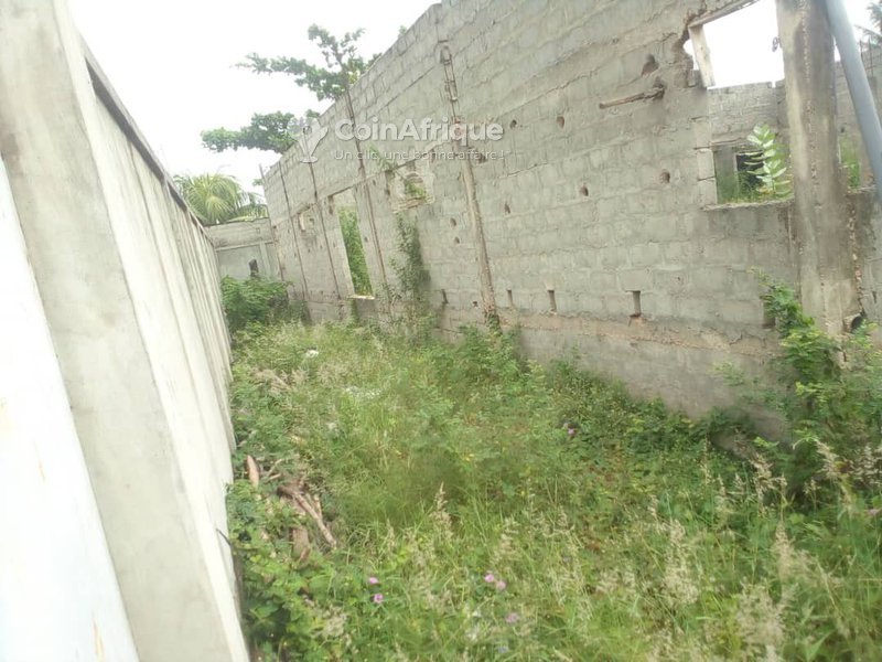 Terrain clôturé avec bâtiment inachevé et titre foncier personnel